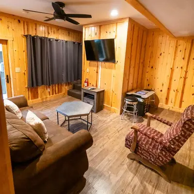 a living room with a couch and a flat screen tv at Overlook - by The Chalets in Logan