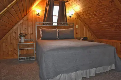 a bedroom with a bed in a wooden cabin at Pine Cone - by The Chalets in Logan