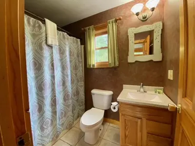 a bathroom with a toilet and a sink at Pine Cone - by The Chalets in Logan