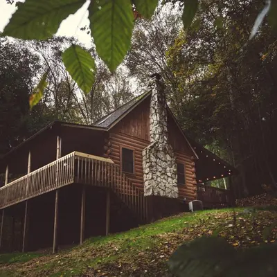 a log cabin on a hill with a fence at Pine Creek - by The Chalets in South Bloomingville