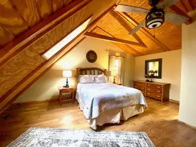 a bedroom with a large bed with a wooden ceiling at Pine Creek - by The Chalets in South Bloomingville