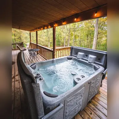 a hot tub on the deck of a cabin at Pine Creek - by The Chalets in South Bloomingville