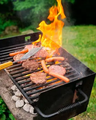 a grill with burgers and hot dogs on it at Pine Creek - by The Chalets in South Bloomingville
