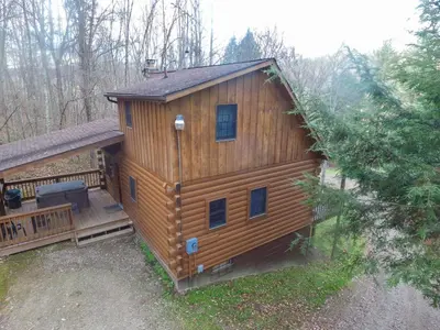 a large wooden cabin with a porch and a deck at Pioneer - by The Chalets in South Bloomingville