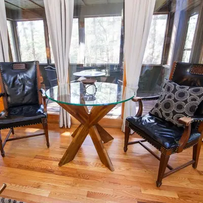 a glass table and two chairs in a room at Ravine - by The Chalets in Logan