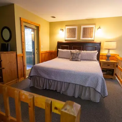 a bedroom with a bed with a white and black comforter at Ravine - by The Chalets in Logan