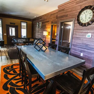 a dining room with a table and a clock on the wall at Rockhouse - by The Chalets in Logan