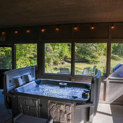 a bath tub in a room with a large window at Rockhouse - by The Chalets in Logan