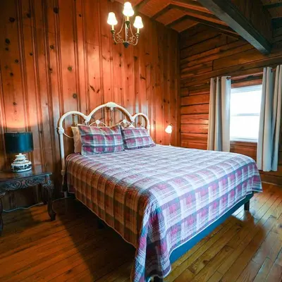 a bedroom with a bed in a log cabin at Settler - by The Chalets in Logan