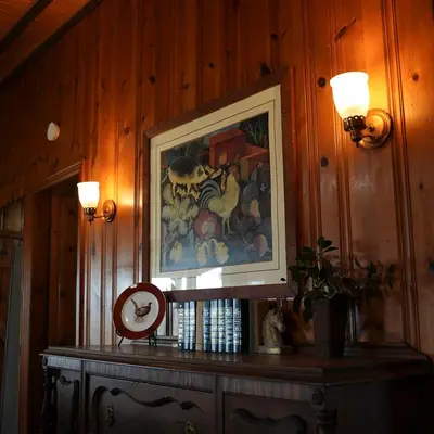 a painting on a wood paneled wall with a table at Settler - by The Chalets in Logan
