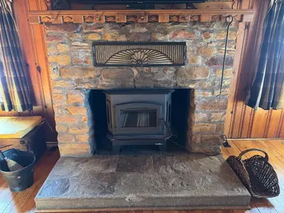 a stone fireplace in a room with a wooden door at Settler - by The Chalets in Logan