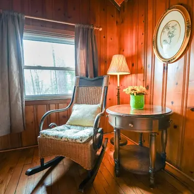 a room with a chair and a table and a lamp at Settler - by The Chalets in Logan