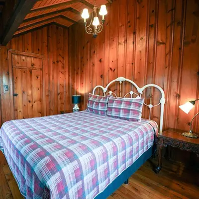 a bedroom with a bed with a checkered blanket at Settler - by The Chalets in Logan