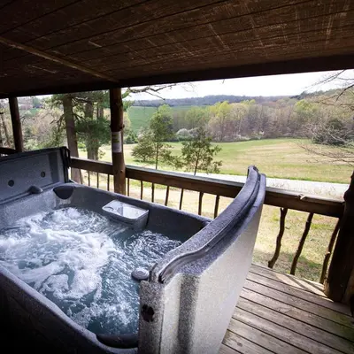 a hot tub sitting on a deck with a view at Settler - by The Chalets in Logan
