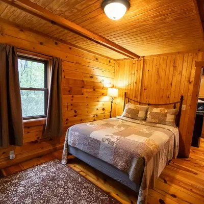 a bedroom with a bed in a log cabin at Sycamore - by The Chalets in South Bloomingville