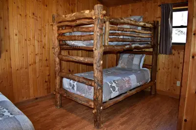a bedroom with a bunk bed in a log cabin at Sycamore - by The Chalets in South Bloomingville