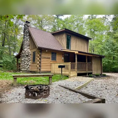 a log cabin with a table in front of it at Timber Ridge - by The Chalets in South Bloomingville