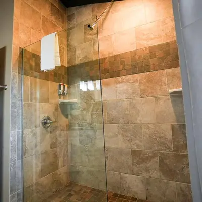 a bathroom with a shower with a glass door at Treetop - by The Chalets in Logan