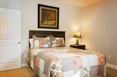 a bedroom with a bed and a picture on the wall at Treetop - by The Chalets in Logan