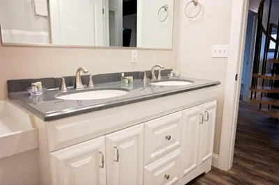 a bathroom with two sinks and a large mirror at Treetop - by The Chalets in Logan