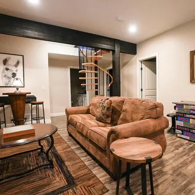 a living room with a brown couch and a table at Treetop - by The Chalets in Logan