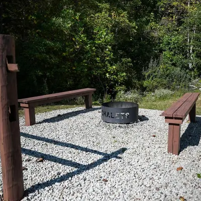 two benches and a fire pit in a park at Treetop - by The Chalets in Logan