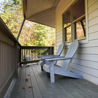 a pair of chairs sitting on the porch of a house at Treetop - by The Chalets in Logan