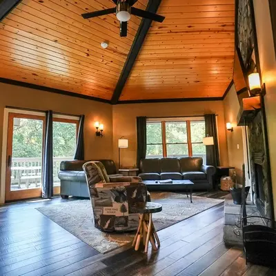 a living room with leather furniture and a wooden ceiling at Treetop - by The Chalets in Logan