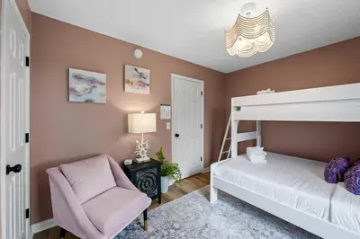 a bedroom with a bunk bed and a chair at 2 BR 1 & half Bath Retreat, Sleeps 7, only 3 Miles to Ark! in Williamstown