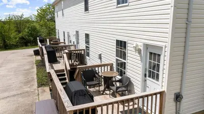 a deck with chairs and tables on a building at 2 BR 1 & half Bath Retreat, Sleeps 7, only 3 Miles to Ark! in Williamstown