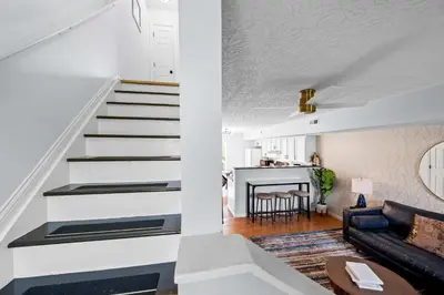 a white staircase in a living room with a couch at 2 BR 1 & half Bath Retreat, Sleeps 7, only 3 Miles to Ark! in Williamstown