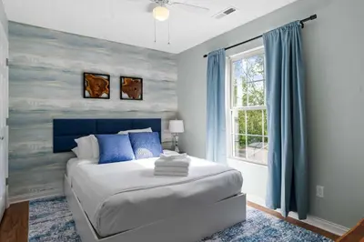 a bedroom with a bed with blue walls and a window at 3BR Condo Near Ark Encounter, 8 Guests, Parking in Williamstown