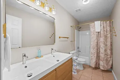a bathroom with a sink and a toilet and a mirror at 3BR Condo for 7 - Only 3 Miles to Ark Encounter! in Williamstown