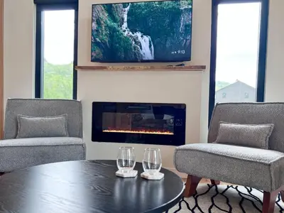 a living room with a table and two chairs and a tv at Hiker's Haven at Three Suns Cabins in Stanton