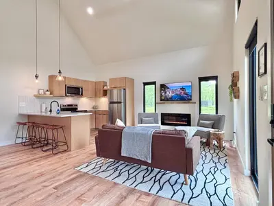 a living room with a couch and a kitchen at Hiker's Haven at Three Suns Cabins in Stanton