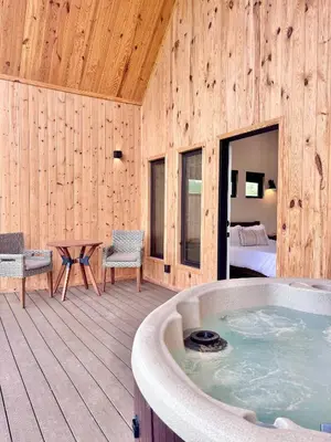 a room with a hot tub and a bedroom at Hiker's Haven at Three Suns Cabins in Stanton