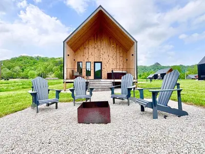 a group of chairs and a house with a piano at Hiker's Haven at Three Suns Cabins in Stanton