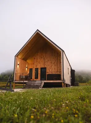 a large wooden barn with a porch and a table at Hiker's Haven at Three Suns Cabins in Stanton