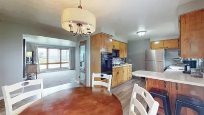 a kitchen with a wooden table and white chairs at The Halftime Highlight-Big Plays, Comfy Stays in Canton