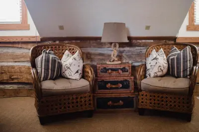 two chairs and a table with a lamp and a nightstand at Getaway Inn at Cooper's Woods in Put-in-Bay
