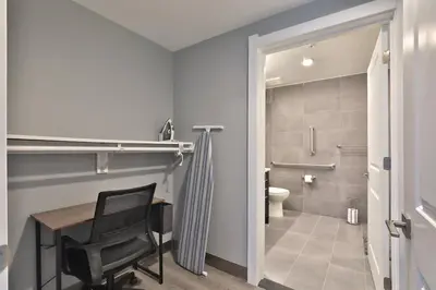 a bathroom with a chair and a desk and a toilet at The Buckeye's Gem Near Downtown & OSU in Columbus