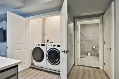 a washing machine in a laundry room with a shower at The Buckeye's Gem Near Downtown & OSU in Columbus