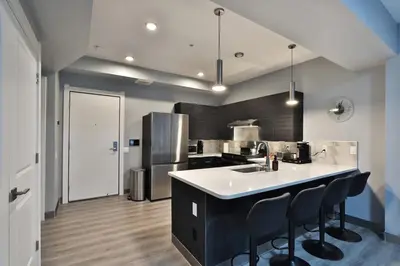 a kitchen with a white counter and a refrigerator at The Buckeye's Gem Near Downtown & OSU in Columbus