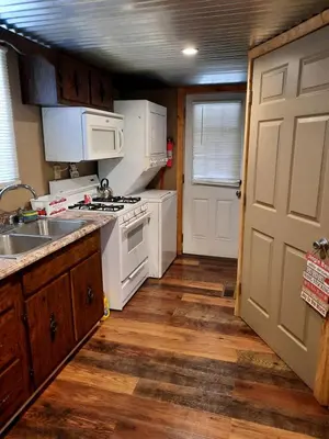 a kitchen with white appliances and a wooden floor at Secluded Cabin Rental, Perfect for an Ohio Retreat in Scio