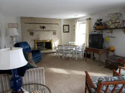a living room with a table and a fireplace at Idyllic Beachfront Vacation Rental on the Shores of Lake Erie in Northern Ohio in Vermilion