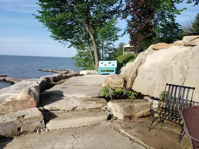 a couple of benches sitting next to the water at Idyllic Beachfront Vacation Rental on the Shores of Lake Erie in Northern Ohio in Vermilion