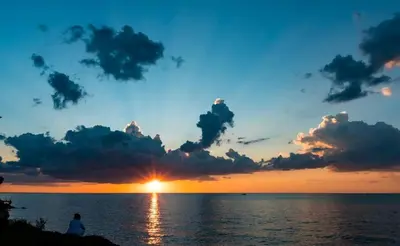 a person sitting on the beach watching the sunset at Idyllic Beachfront Vacation Rental on the Shores of Lake Erie in Northern Ohio in Vermilion