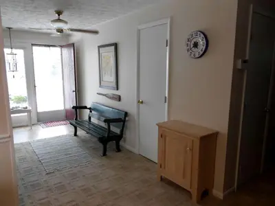 a room with a bench and a clock on the wall at Idyllic Beachfront Vacation Rental on the Shores of Lake Erie in Northern Ohio in Vermilion