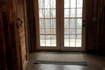 a room with an open door with a rug in front at Rustic Octagon-Shaped Cabin for a Glamping Getaway near Huntington, West Virginia in Genoa