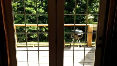 an open door with a view of a garden through a window at Rustic Octagon-Shaped Cabin for a Glamping Getaway near Huntington, West Virginia in Genoa